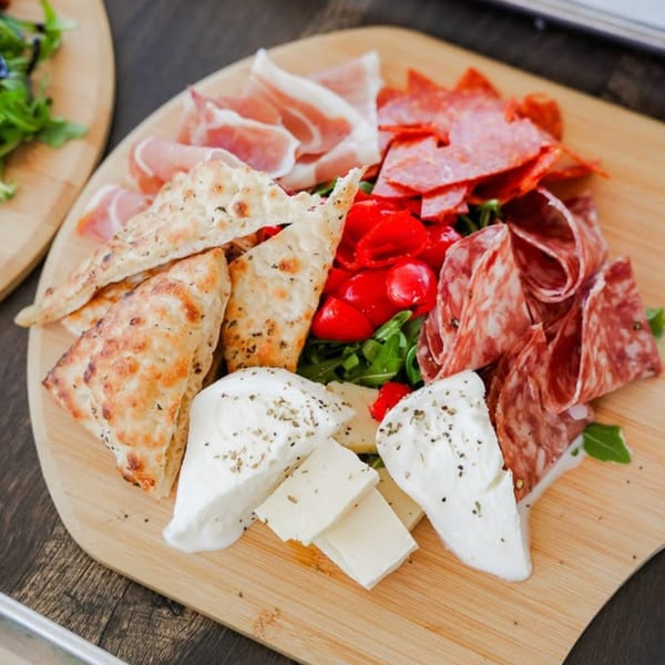 DeSano Pizzeria Napoletana charcuterie board with meats, cheeses, roasted peppers, and flatbread.